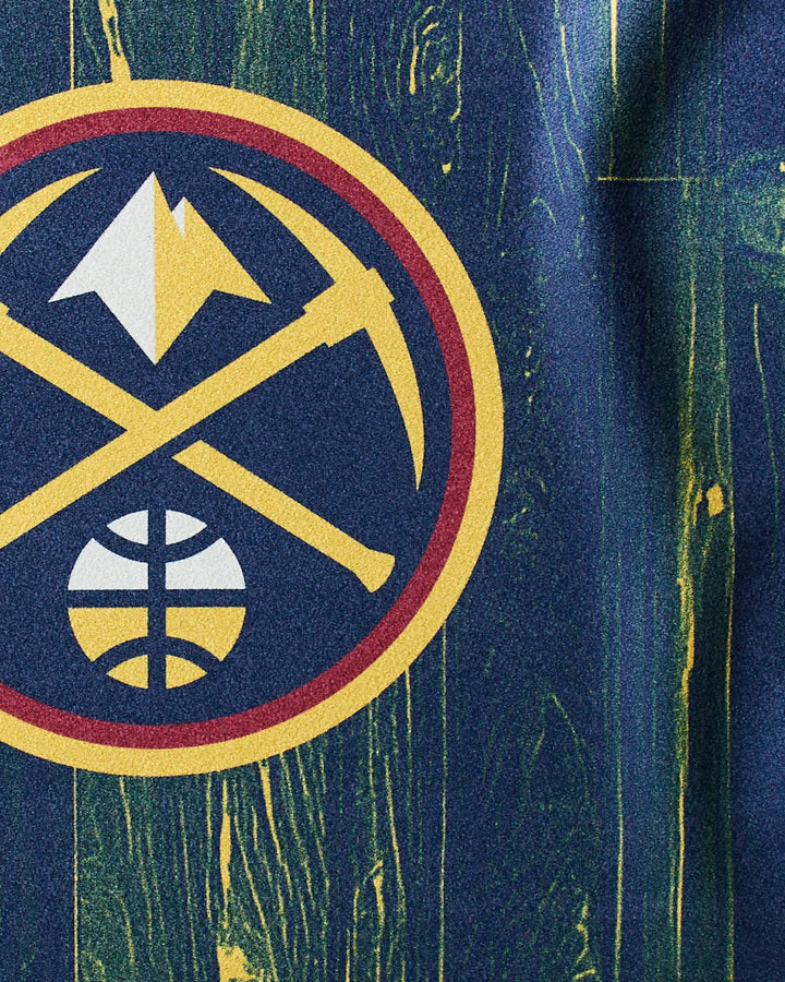 The NBALAB x Geometry "Nuggets Zone" fitness towel features a gold pickaxe and mountain Nuggets logo with a basketball, set on a wood-textured background with blue and yellow streaks—ideal as a quick-drying NBA gym accessory.