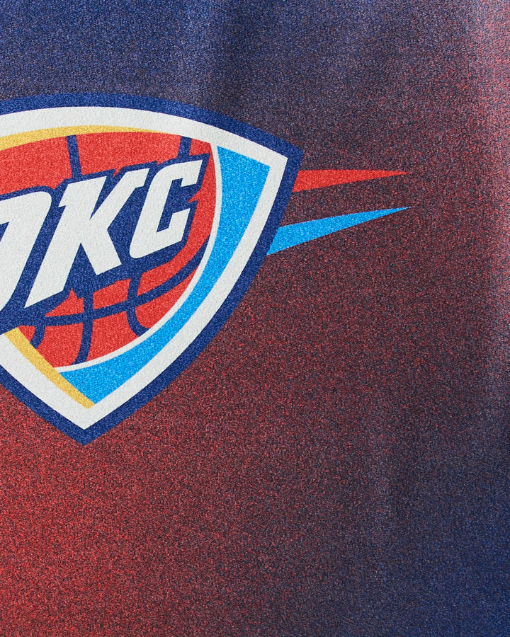 The image features the OKC Fade NBA fitness towel by NBALAB x Geometry, displaying a close-up of the Oklahoma City Thunder logo with "OKC" over a basketball and bold blue, red, and yellow lines on textured fabric.