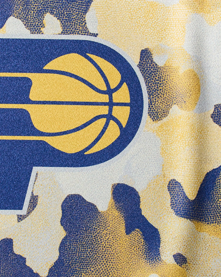 Close-up of the Indiana Pacers logo on a blue, yellow, and white camo fabric background, featured on the "Pacers Camo" NBA fitness towel by NBALAB x Geometry—perfect for workouts.