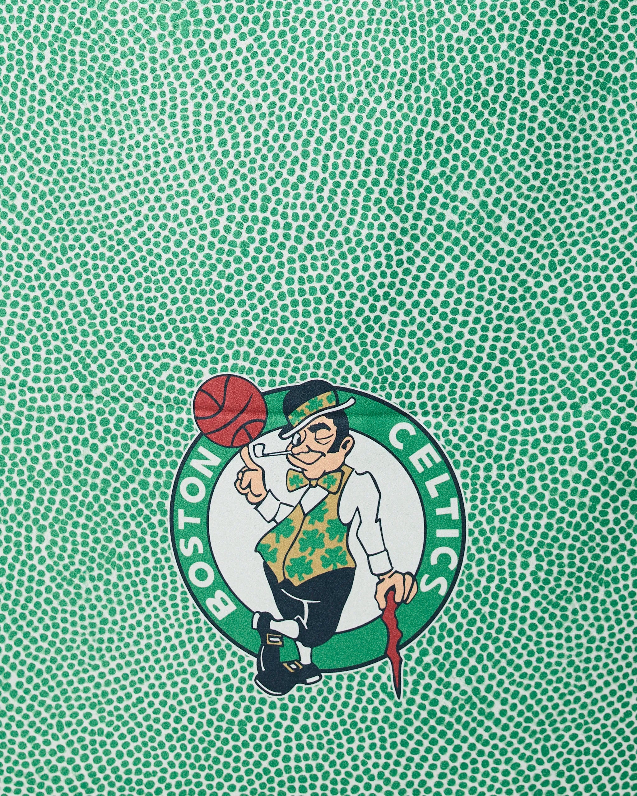 The Geometry Celtics Grip features a leprechaun spinning a basketball on a green, textured background inspired by the Celtics.