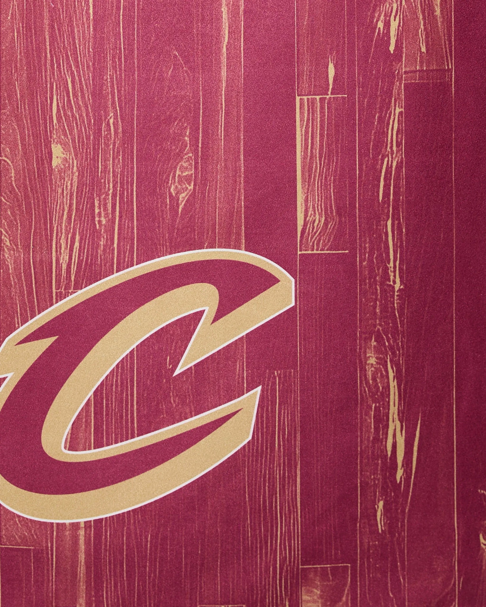 Partial view of the Cavaliers Zone by Geometry—a stylized maroon and gold basketball court floor featuring a large C logo on a wood-patterned background, reminiscent of the Cleveland Cavaliers.