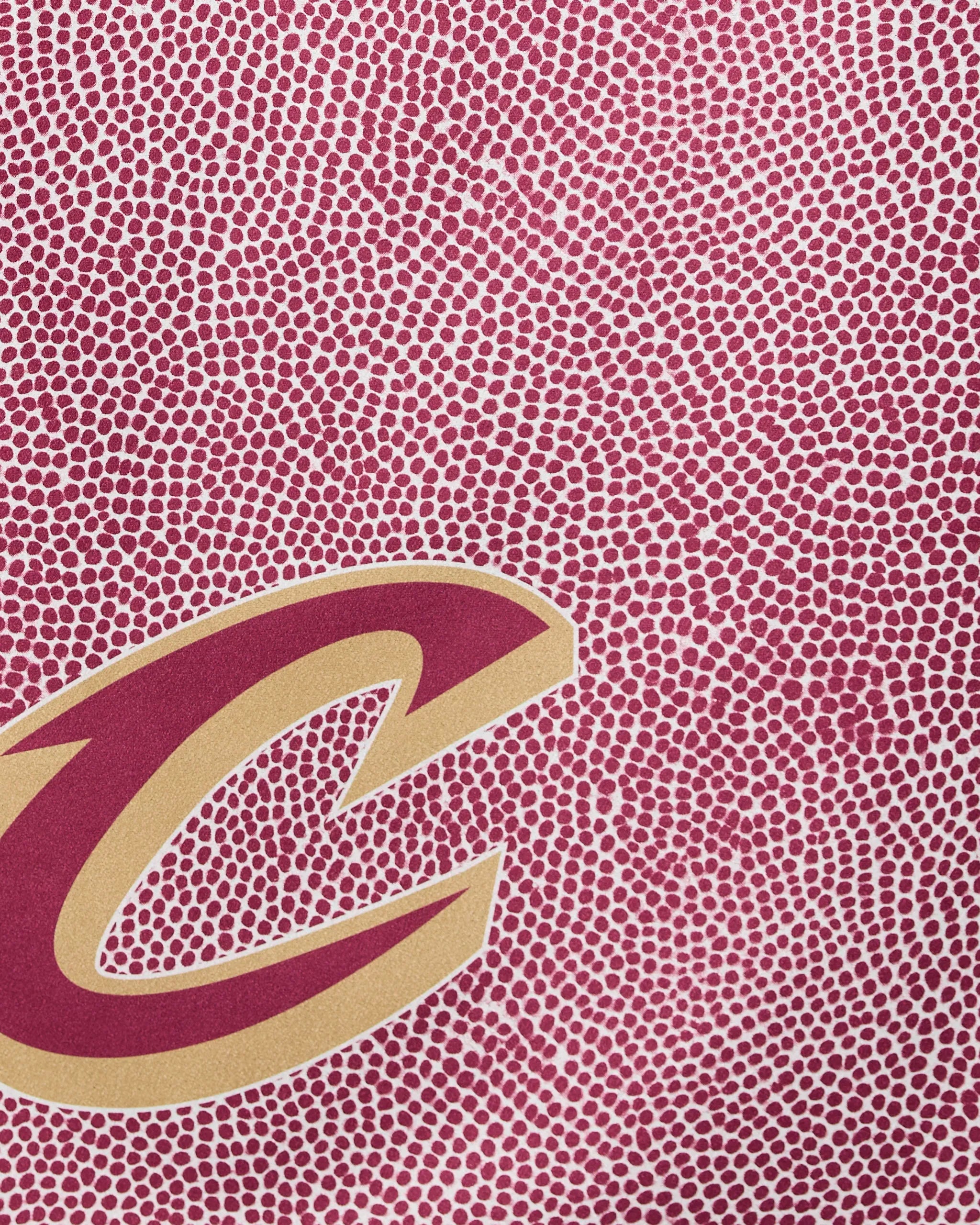 Close-up of the Geometry Cavaliers Grip: a maroon and gold letter C on a textured maroon background with small white dots, mimicking a basketball surface.