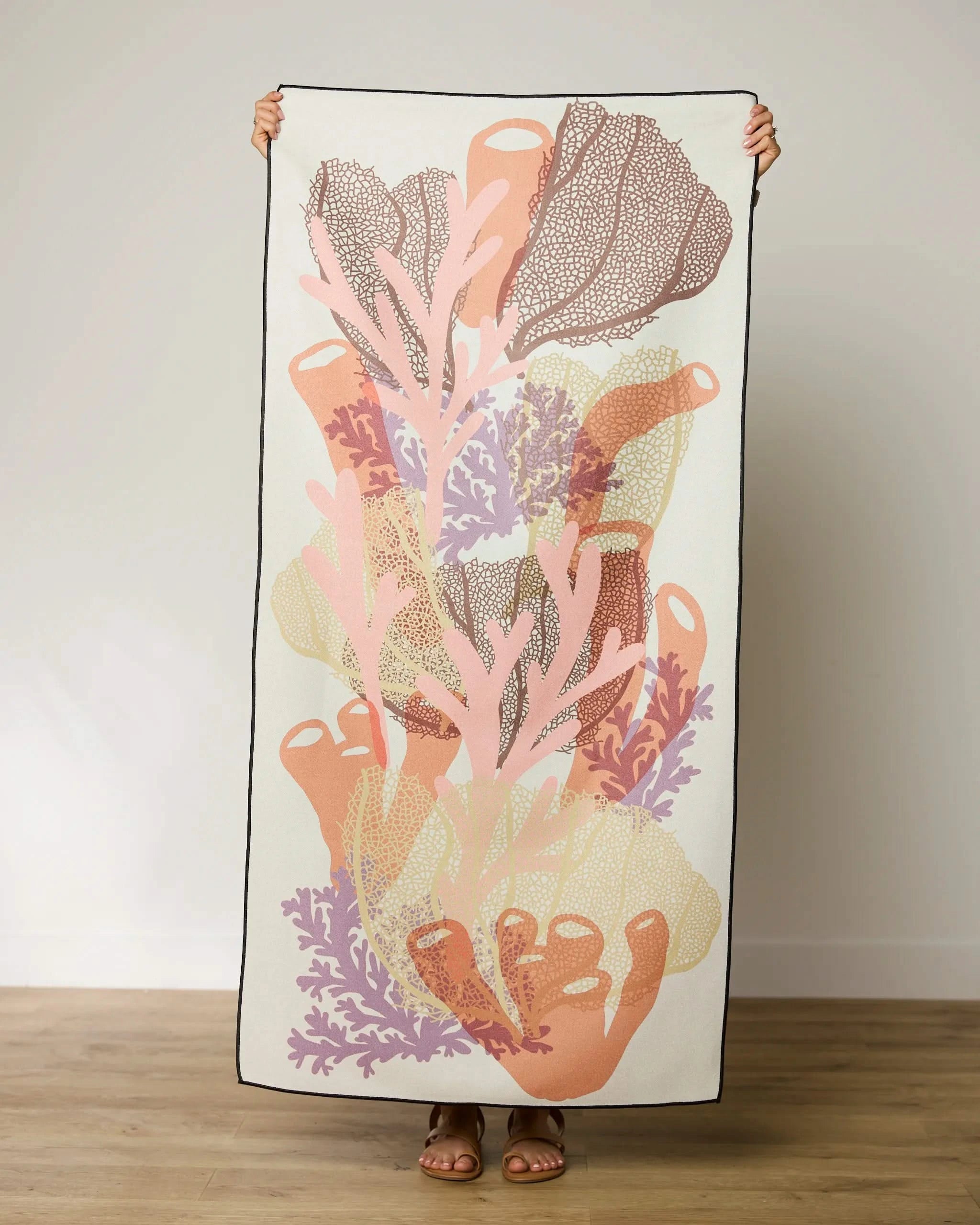 A person holding the GEOMETRY Barrier, a large, quick-drying beach towel.