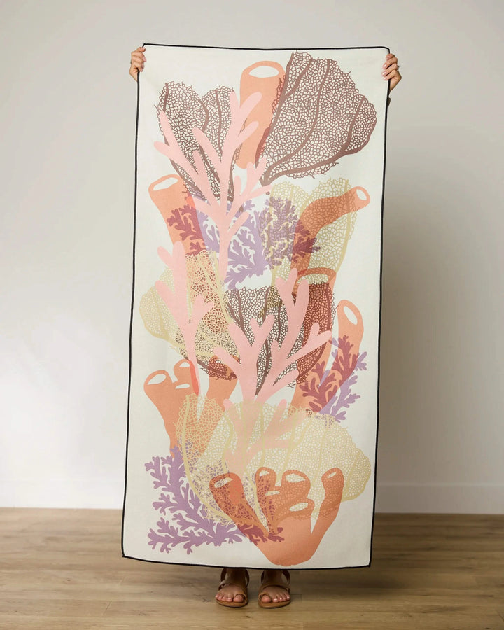 A person holding the GEOMETRY Barrier, a large, quick-drying beach towel.