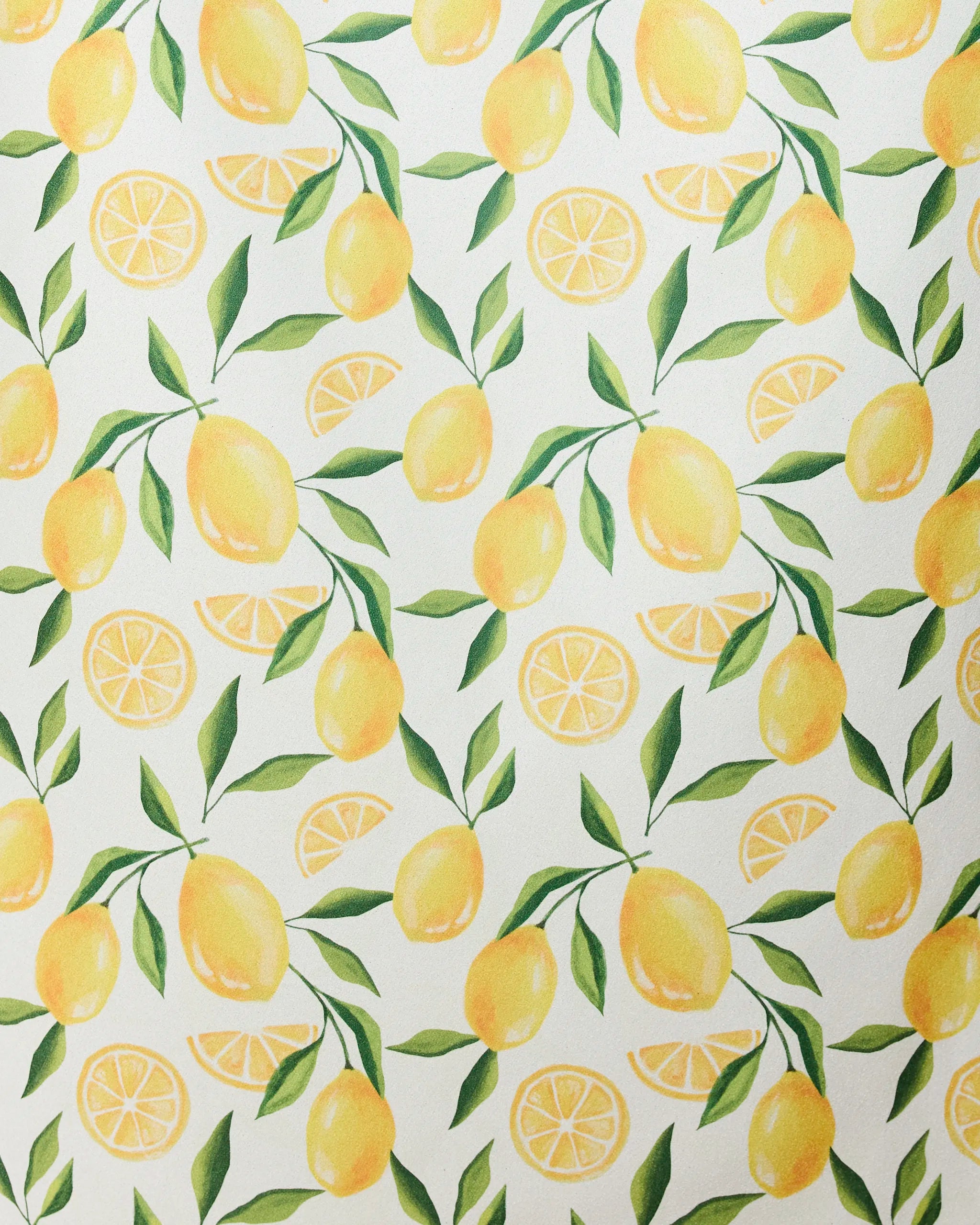 The Limoncello micro-loop beach towel by GEOMETRY features a seamless pattern of whole yellow lemons, lemon slices, and green leaves on white—crafted from recycled materials for a fresh, summery style.