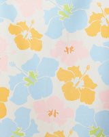 The GEOMETRY Hula Hues towel features a seamless pattern of large yellow, blue, and pale pink hibiscus flowers with light green accents on an off-white background for a bright, airy vintage tropical look. Quick-drying design.