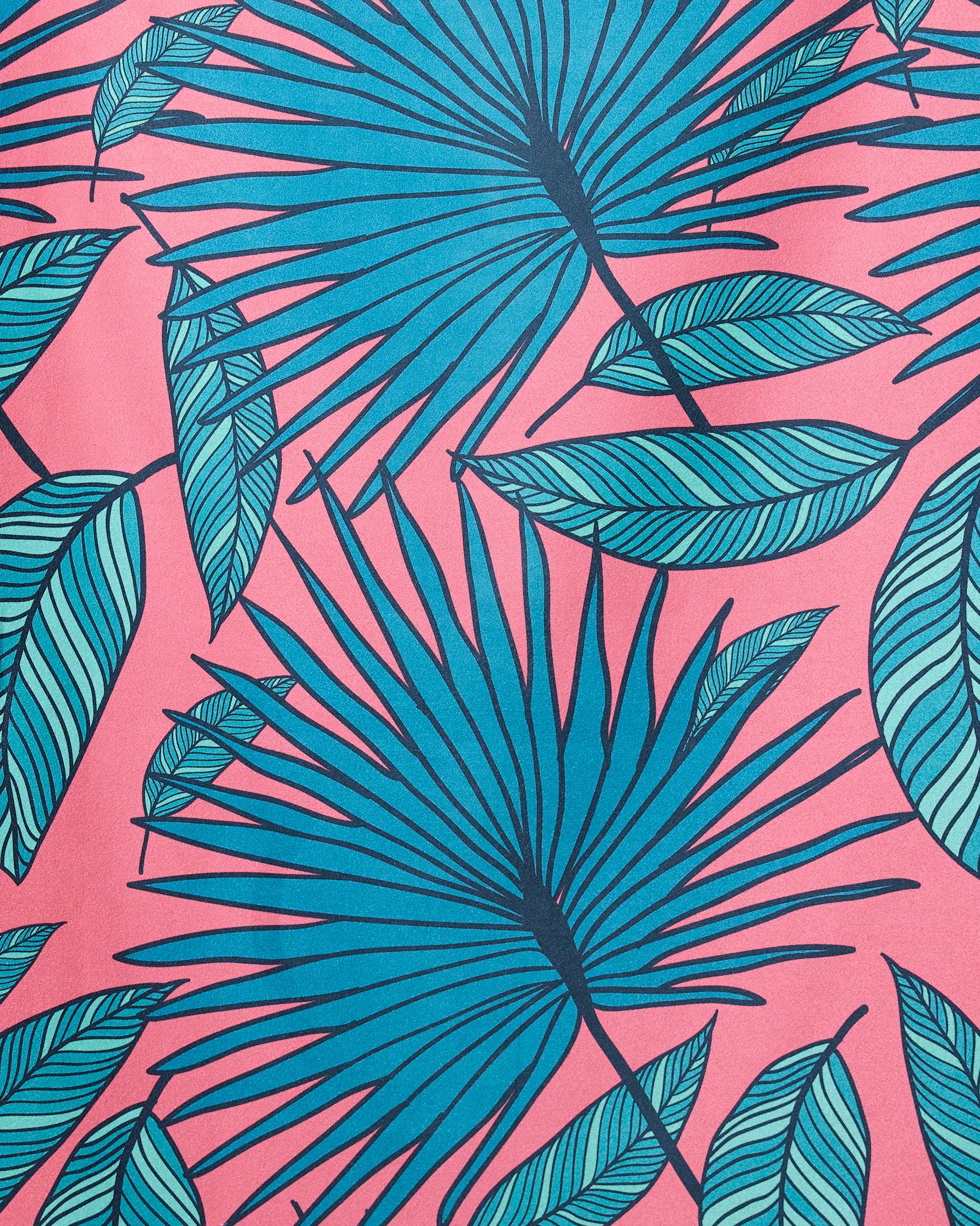 The GEOMETRY Jazzy Jungle Micro-loop beach towel features blue palm and green striped leaves on a pink background, creating a vibrant tropical pattern with quick-drying fabric.