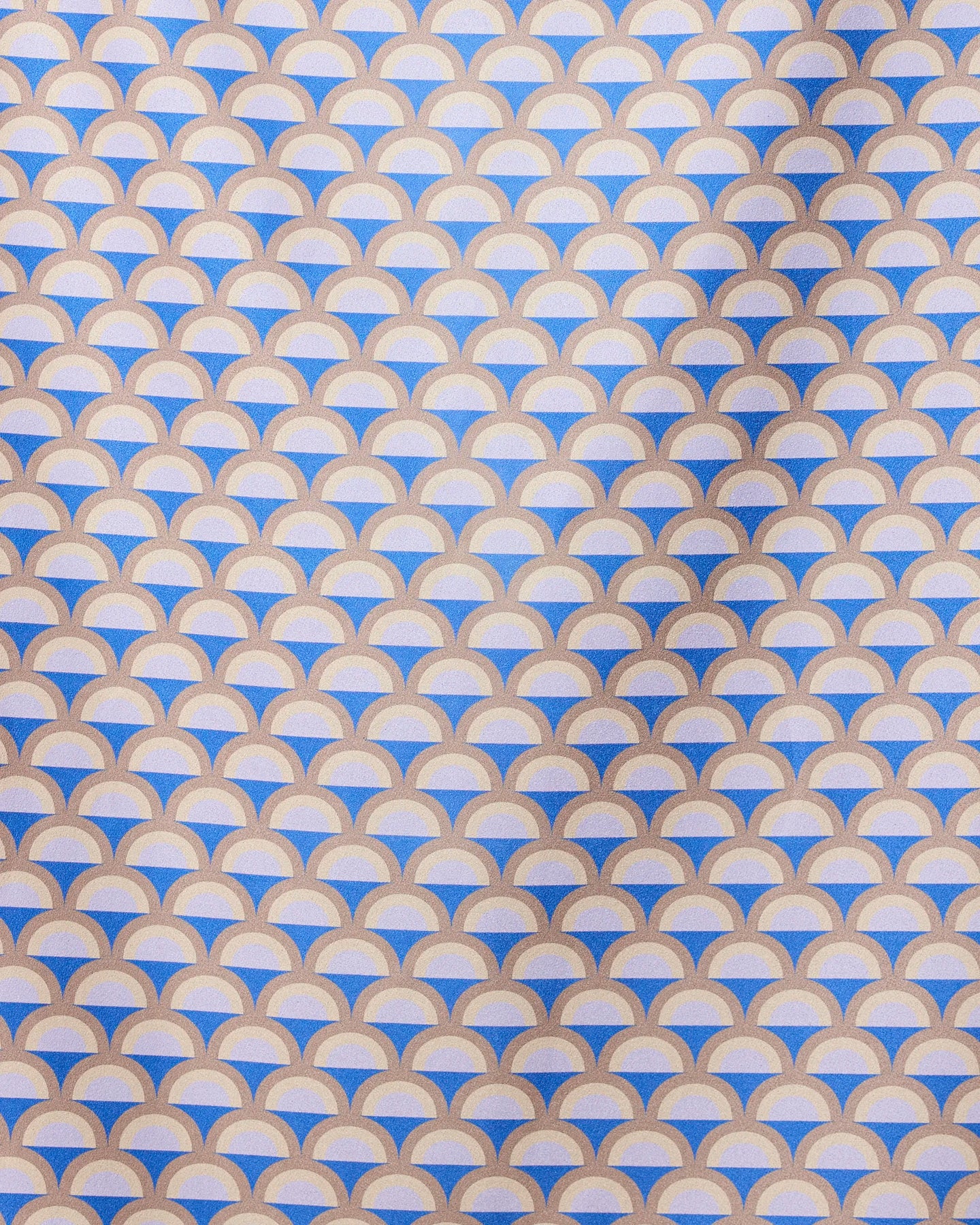 A repeating geometric pattern of overlapping mauve, beige, and white semicircles forms a scallop design on the GEOMETRY Mauve Mounds quick-drying beach towel, with diagonal shadows highlighting its textured surface.