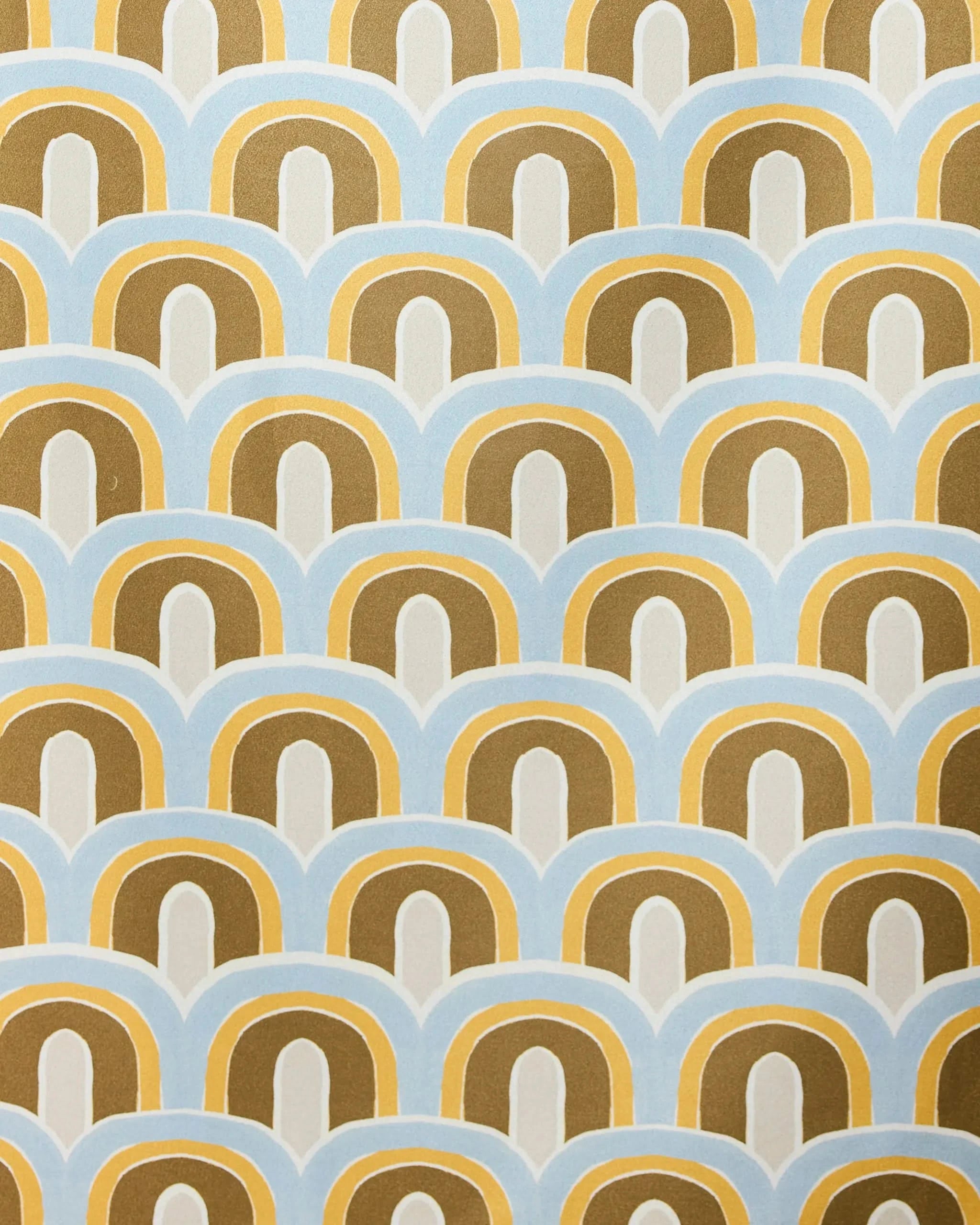 A repeating geometric pattern of overlapping arches in gold, brown, blue, and white gives the GEOMETRY Rained On Beach Towel a retro look—crafted from recycled materials for quick-drying convenience.