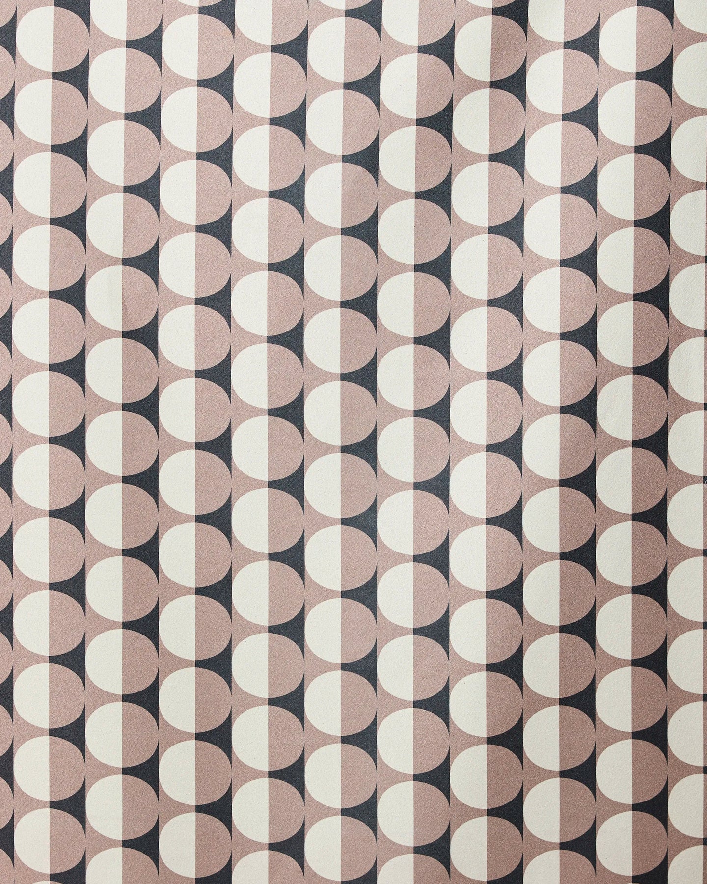 A retro, symmetrical design featuring repeating circles split into black and beige halves decorates the GEOMETRY Retro Round Light beach towel, crafted from recycled materials.