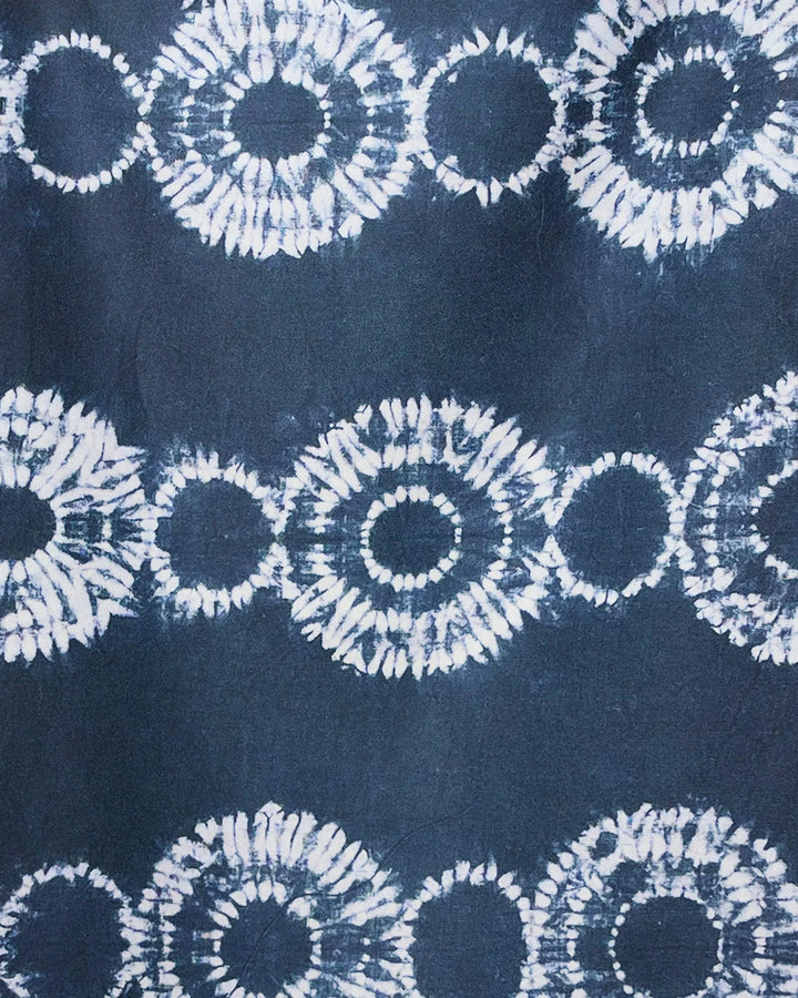 The GEOMETRY Shibo Stars micro-loop beach towel features abstract dark blue fabric with interconnected white tie-dye circles in horizontal rows, creating a striking geometric design that’s quick-drying and perfect for the beach.
