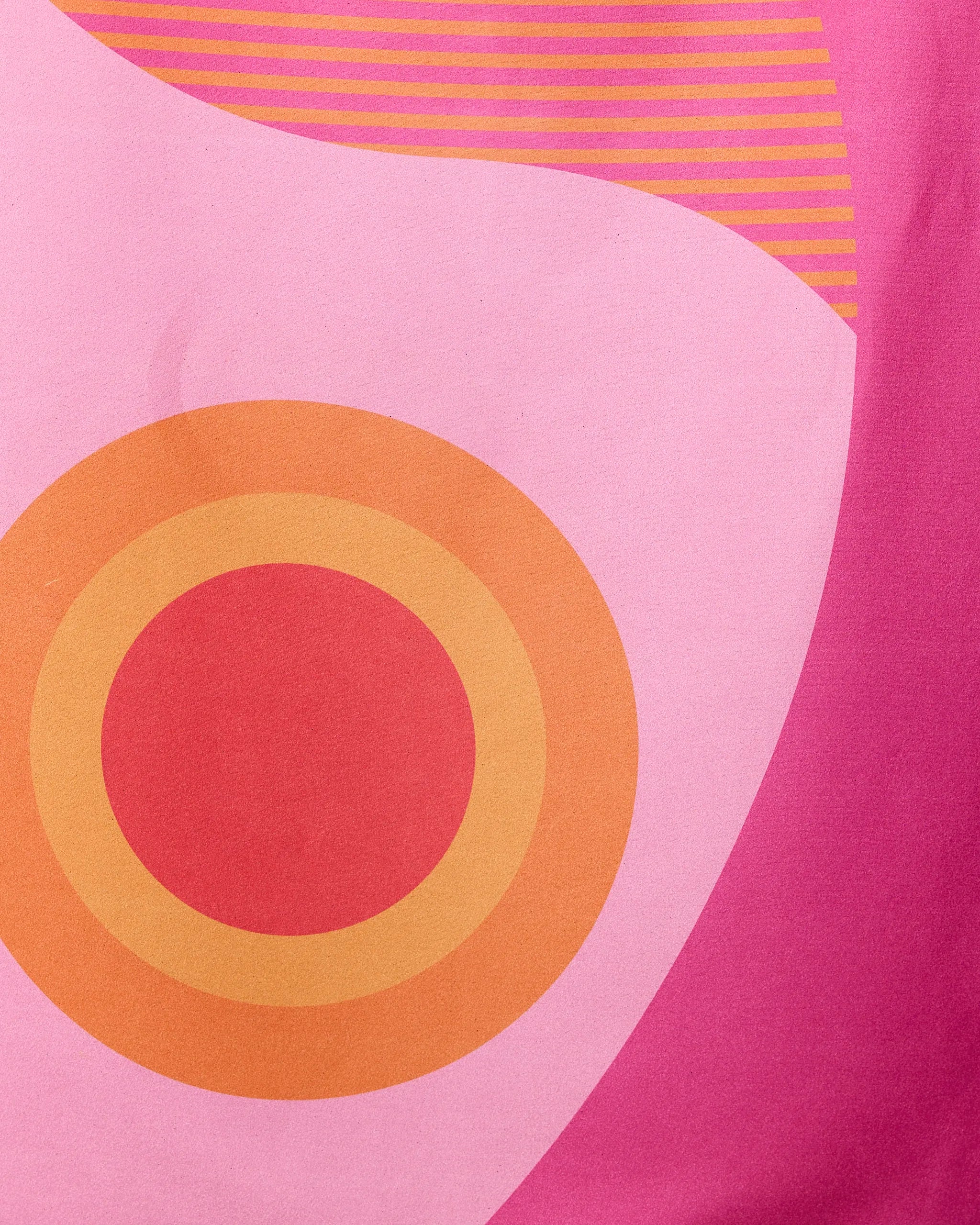 Abstract design with a large orange concentric circle on pink, curved shapes, and orange lines—perfect for the Round Trip Beach Towel by GEOMETRY, crafted from recycled materials.