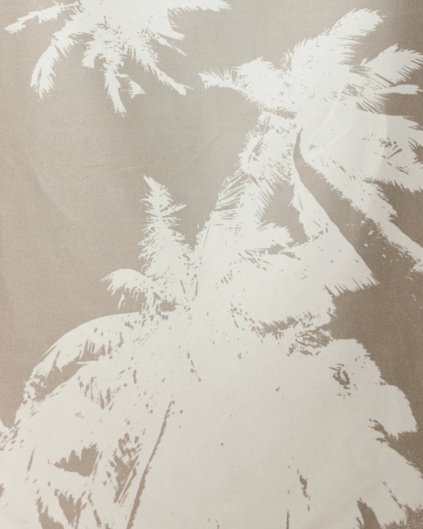 Beige-toned image featuring a white, stylized illustration of tall palm trees—like those on our GEOMETRY Sandy Palms towel—seen from below, with fronds spreading out toward the edges of the frame.