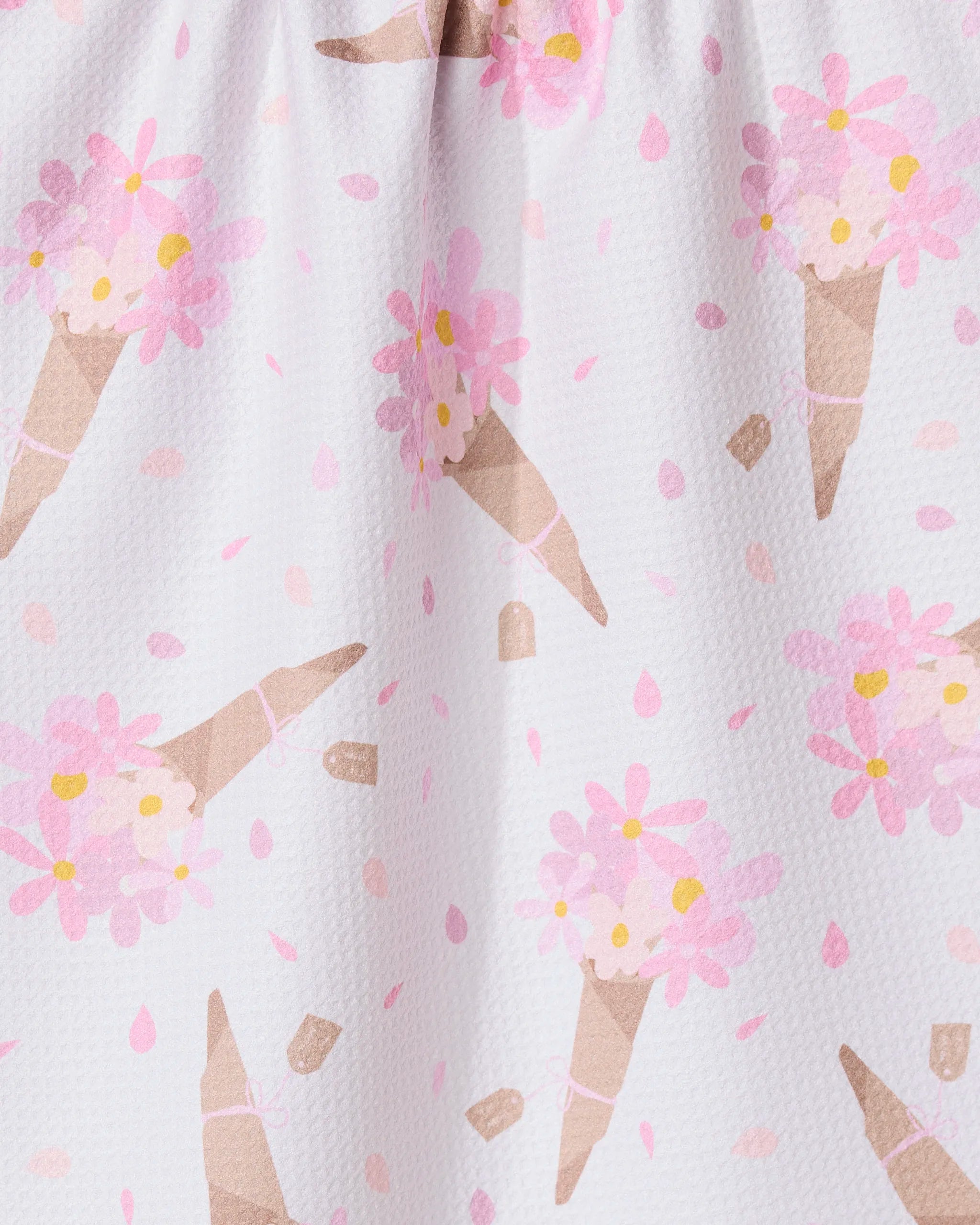 A close-up of the GEOMETRY Gorgeous Gift absorbent dish towel, showcasing a playful ice cream cone pattern with pink flowers and dots on a white background.