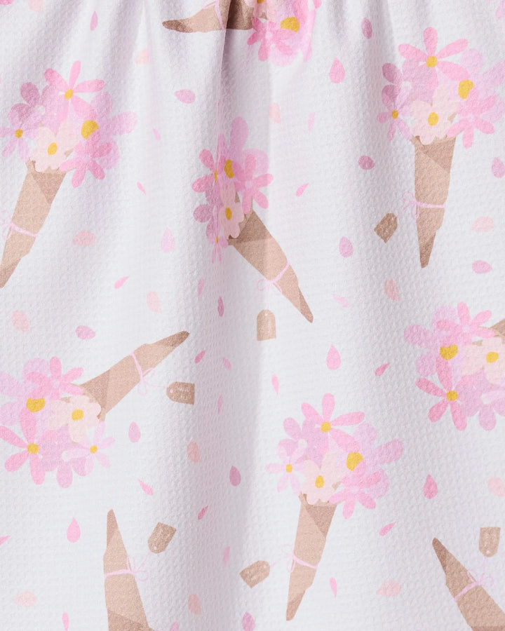 A close-up of the GEOMETRY Gorgeous Gift absorbent dish towel, showcasing a playful ice cream cone pattern with pink flowers and dots on a white background.