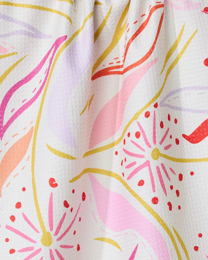The GEOMETRY Grand Bloom kitchen towel features wavy lines and starbursts in pink, red, yellow, orange, and lavender on white. Made from recycled materials, it adds an eco-friendly touch to your kitchen.