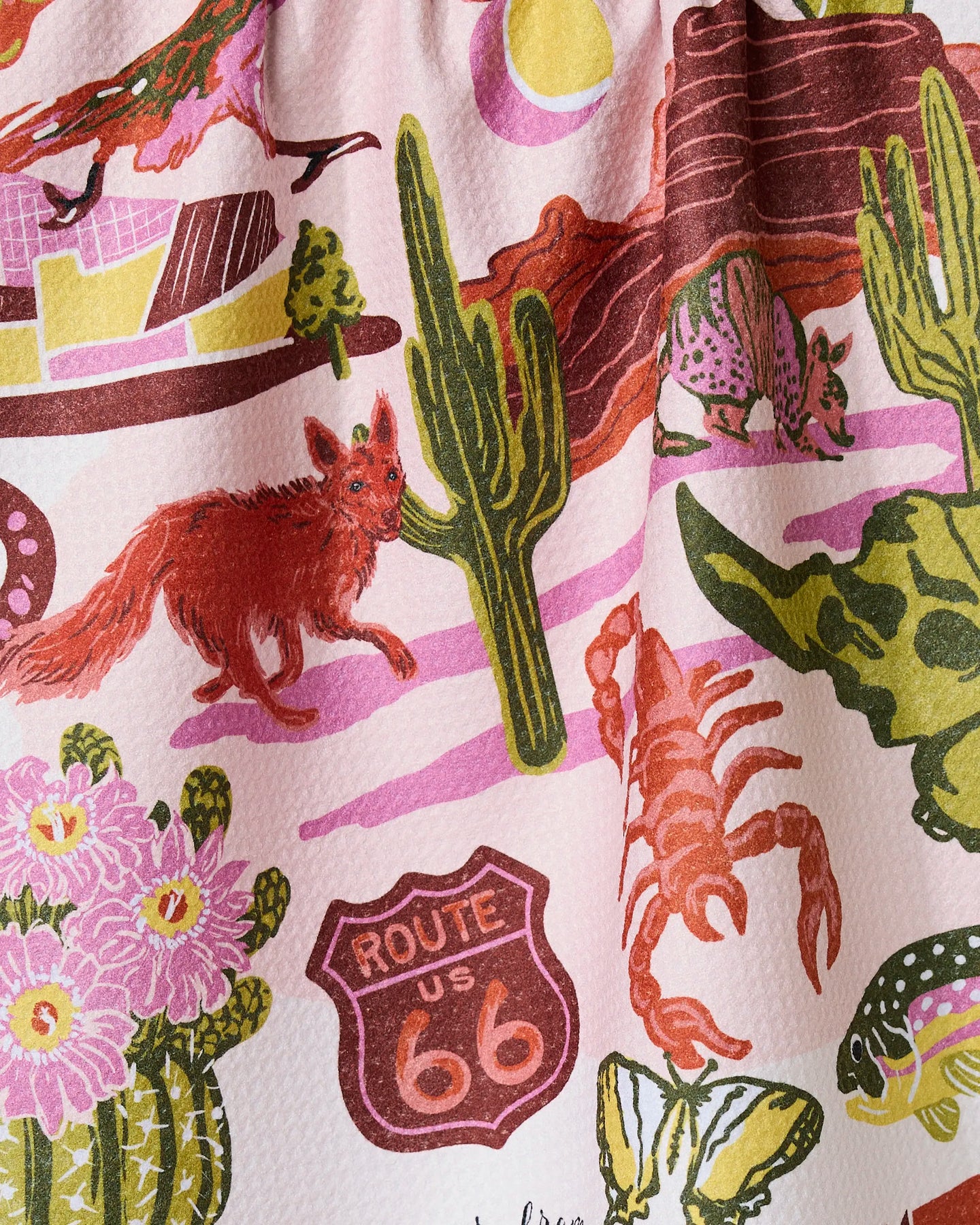 The Greetings From Arizona recycled kitchen towel by Geometry features a vibrant design with a fox, armadillo, cactus, Route 66 sign, pink clouds, and desert wildlife—bringing eco-friendly charm to your kitchen.