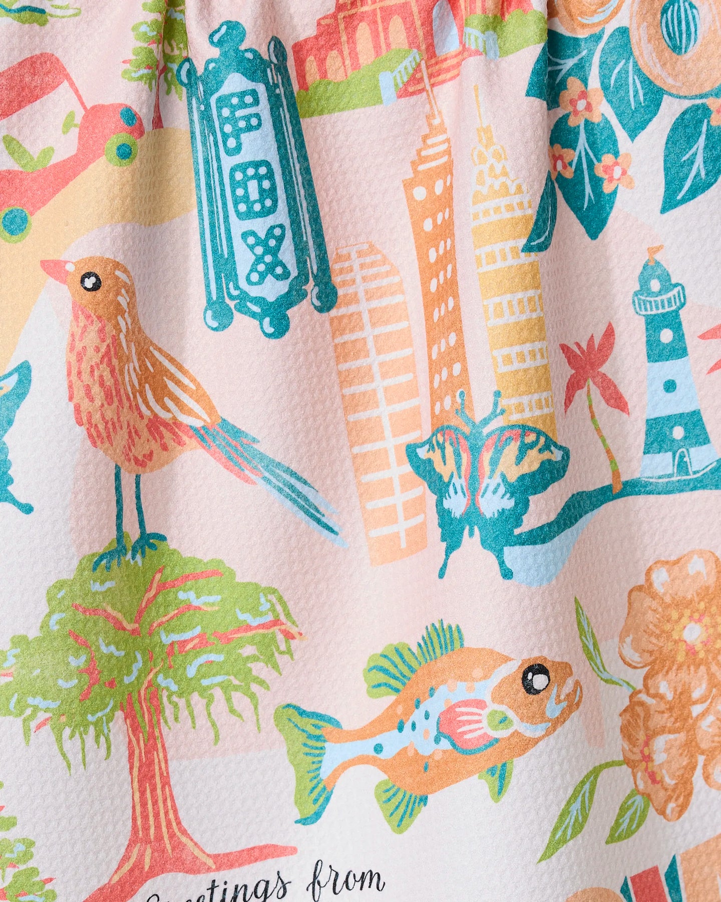 “Greetings From Georgia” by Geometry features a colorful watercolor illustration of birds, fish, butterflies, trees, flowers, a lighthouse, buildings, and a vintage FOX theater sign on an ultra-absorbent tea towel made from recycled materials.