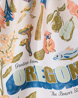 The Geometry Greetings From Oregon eco-friendly kitchen towel features colorful Oregon motifs—bird, mushrooms, beaver, pears, flowers, and fish—with “Greetings from OREGON The Beaver St.” text. Perfect as an absorbent dish towel.
