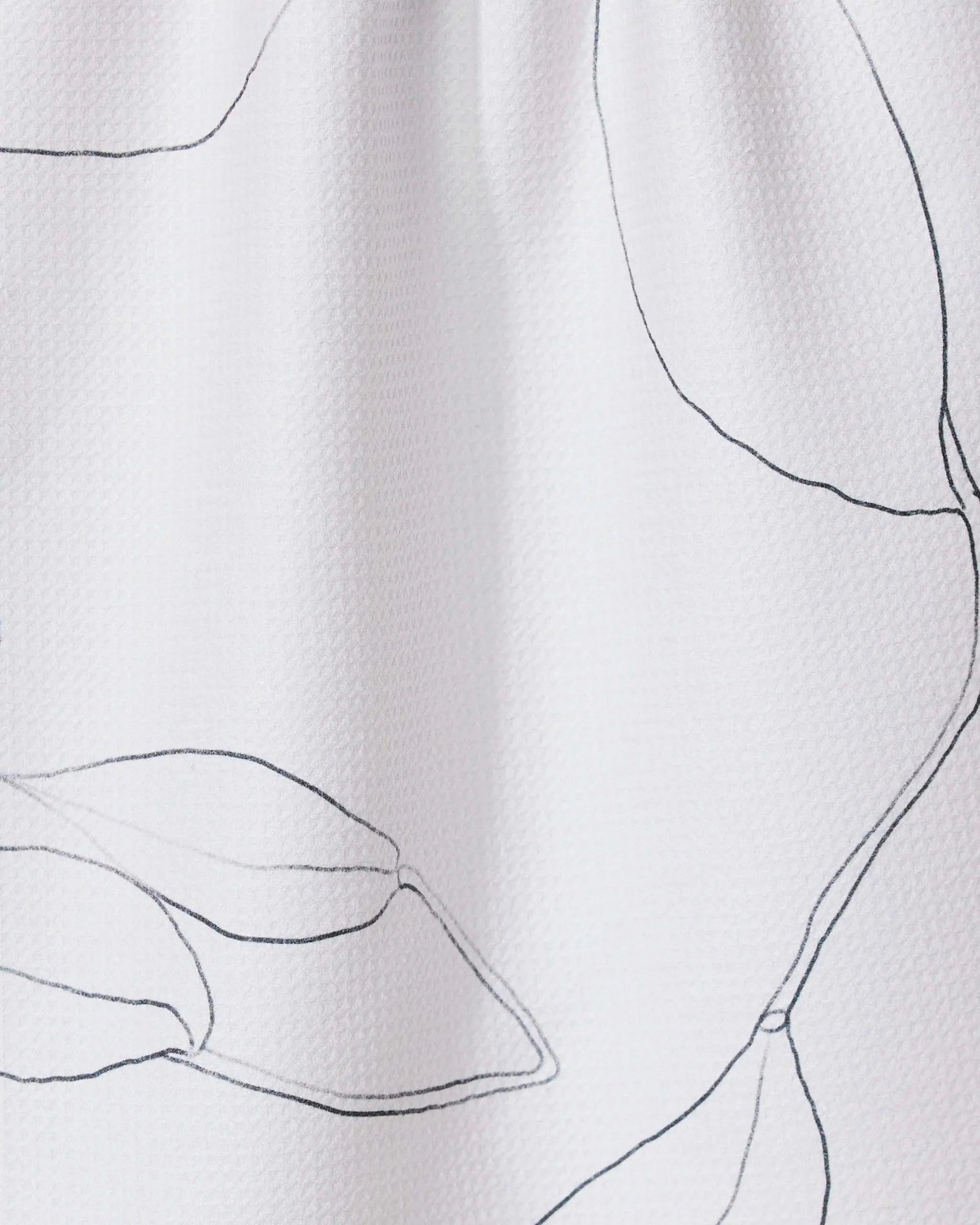 The Grown tea towel by GEOMETRY features white textured fabric with a minimalistic black line drawing of large leaves, offering a modern and airy look—stylish and functional for elevating your kitchen décor.