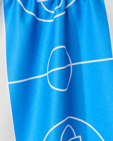 A close-up of the GEOMETRY Hoops tea towel shows its blue fabric with a white soccer field design; the ultra-absorbent towel is slightly wrinkled.