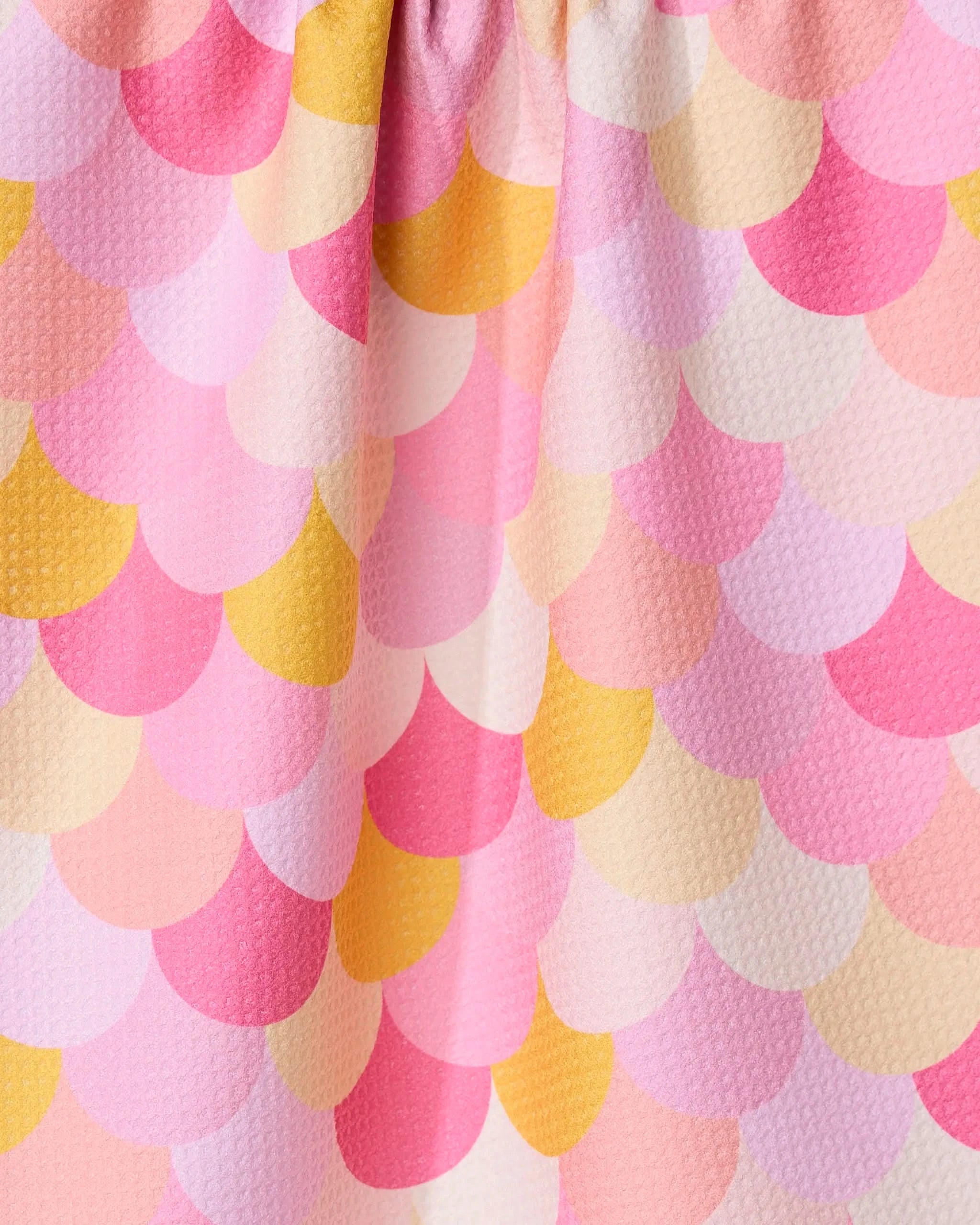 The GEOMETRY Inherit dish towel features a colorful scallop pattern with overlapping pink, yellow, orange, and white semicircles. Its absorbent, soft texture and gentle folds make it perfect for brightening any kitchen.