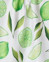 The GEOMETRY Lima kitchen towel features bright, watercolor-style limes, slices, wedges, and green leaves on a white textured background. Made from recycled materials.