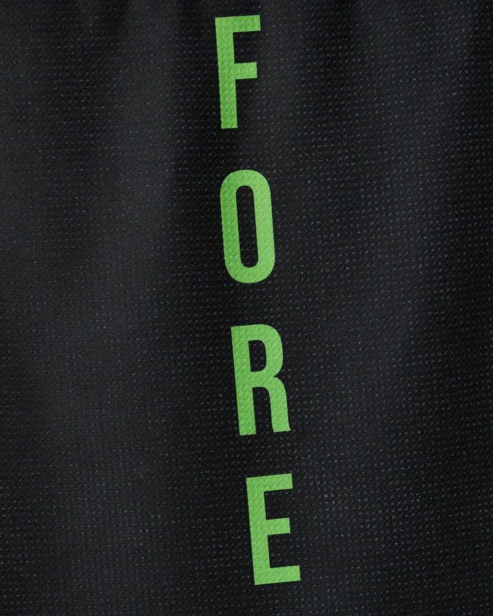 The GEOMETRY Fore tea towel features the word FORE in green capital letters arranged vertically on a textured black background. Made from recycled materials, it is quick-drying and eco-friendly.