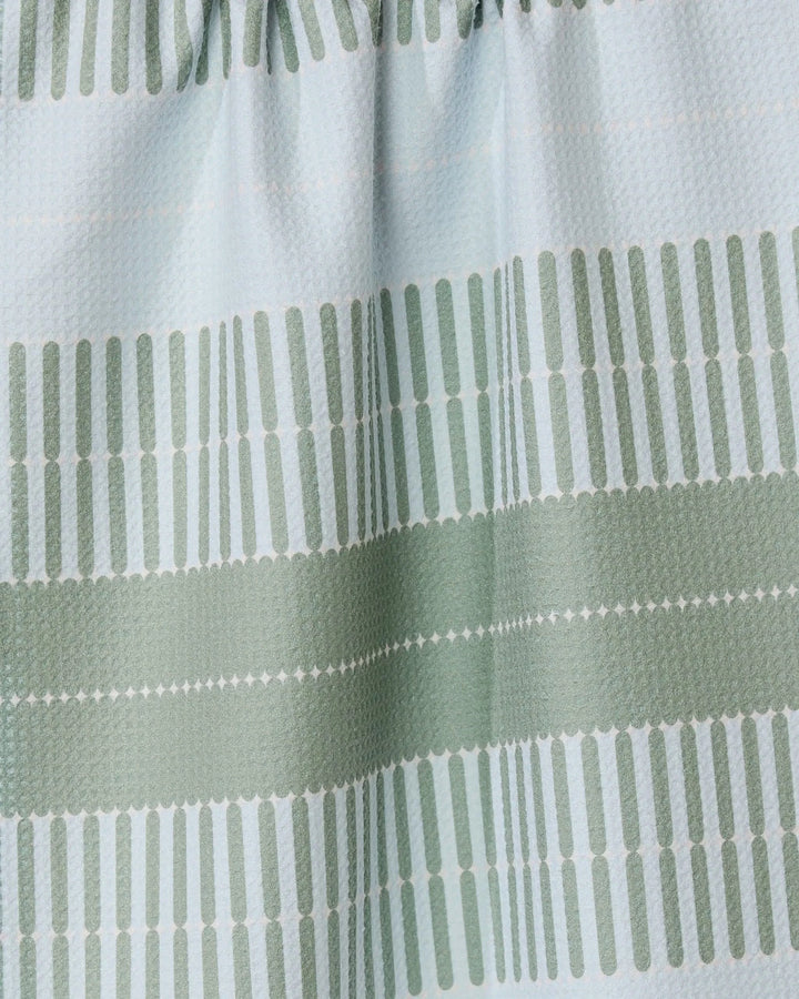 The Bâton Vert tea towel by GEOMETRY features light blue fabric with green horizontal stripes made of small vertical dashes. Its ultra-absorbent, textured material is slightly gathered at the top for a stylish look.