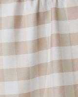 Close-up of the GEOMETRY Betty Bakes tea towel in beige and white gingham, highlighting its textured, eco-friendly fabric and gentle folds—an absorbent, stylish kitchen accessory.