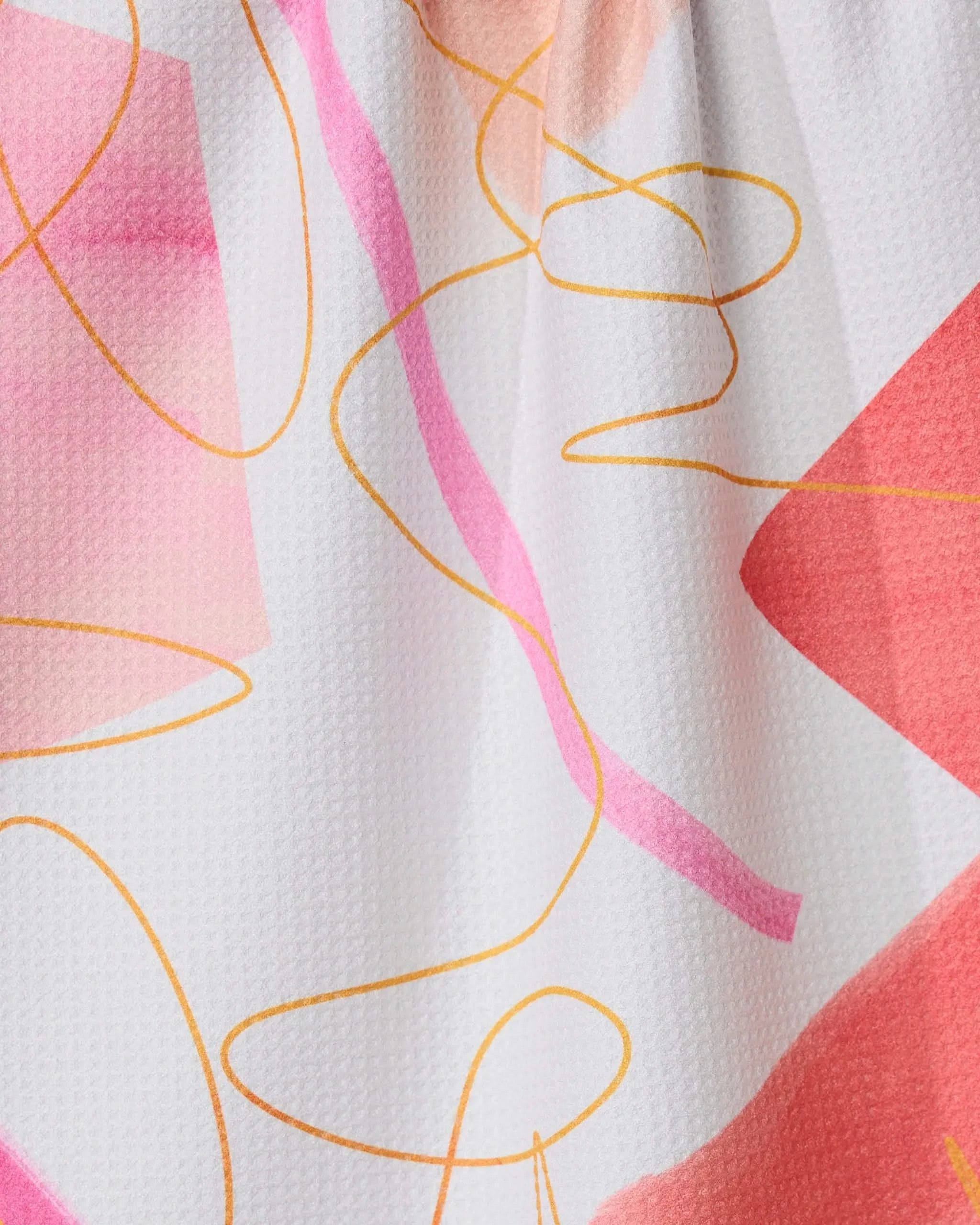 Memories kitchen towel by GEOMETRY features an abstract pattern of pink and peach geometric shapes with yellow curves on a white, textured recycled fabric.