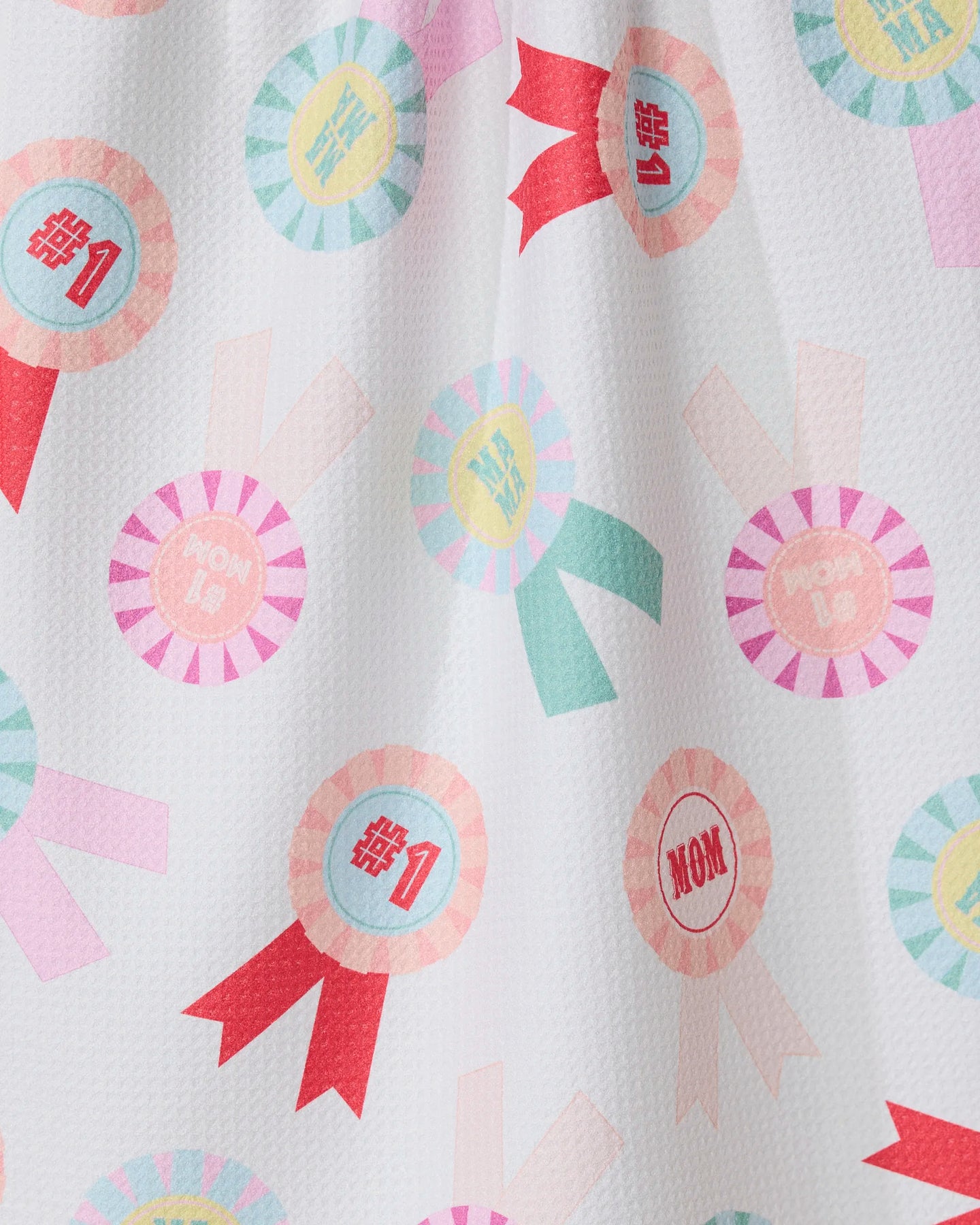 The GEOMETRY Number One Mom towel features colorful rosettes with #1 and MOM text in pink, blue, and yellow on white. Ultra-absorbent and stylish, its perfect for use as a kitchen tea towel.
