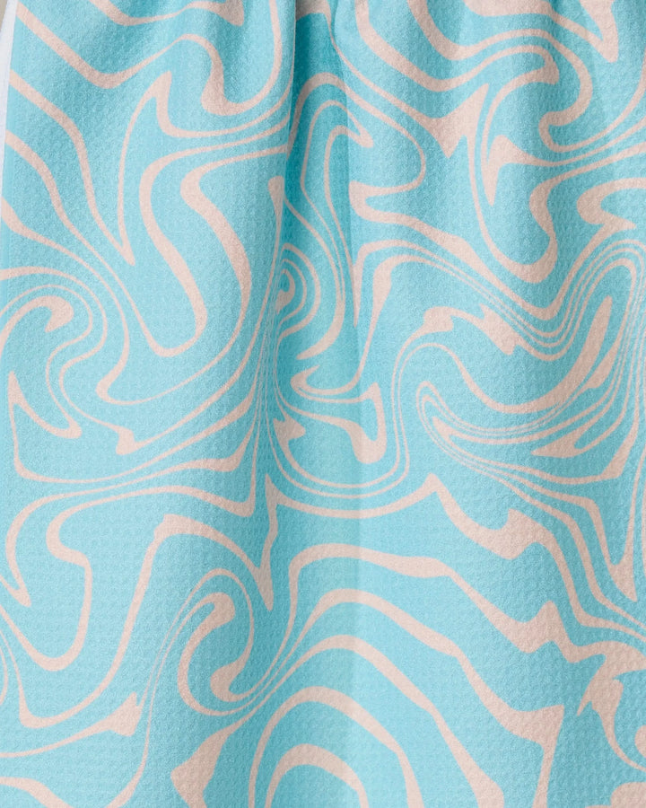 The Patience tea towel by GEOMETRY is light blue, crafted from recycled materials, and features a textured surface with abstract cream-colored wavy swirls in a marble-like design.