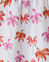 GEOMETRYs Pink Palms is an eco-friendly white kitchen towel with a textured finish, featuring evenly spaced, stylized palm trees in pink, orange, and red with sketchy outlines.