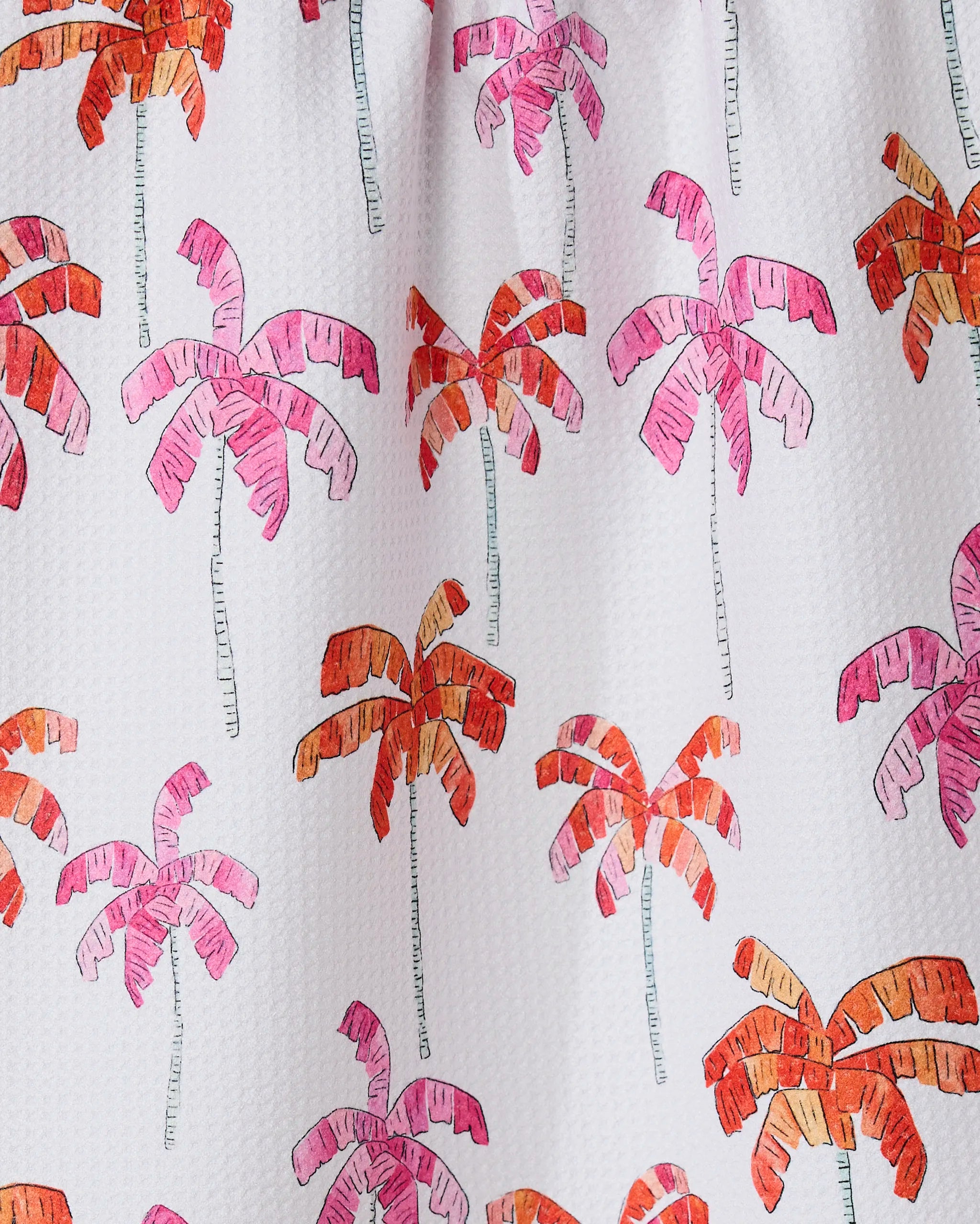 GEOMETRYs Pink Palms is an eco-friendly white kitchen towel with a textured finish, featuring evenly spaced, stylized palm trees in pink, orange, and red with sketchy outlines.