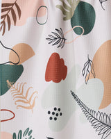 Plated Ferns by GEOMETRY features an abstract pattern of organic shapes and botanical elements in green, peach, black, and red on a light background. This playful, modern tea towel is made from recycled materials.