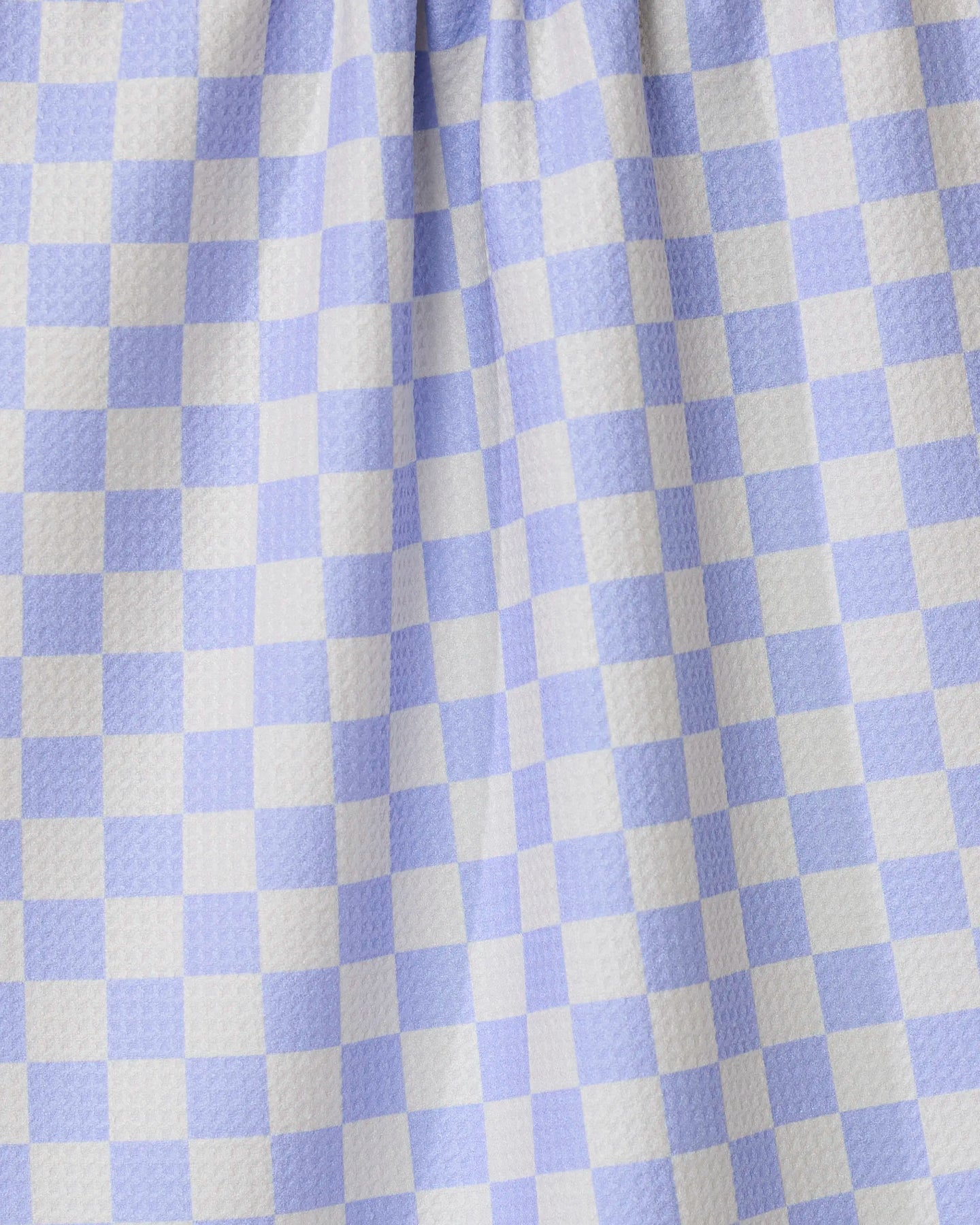 Close-up of Purple Picnic by GEOMETRY, featuring purple and white gingham checkered fabric with a textured surface and gentle folds—perfect for an ultra-absorbent tea towel in any kitchen.