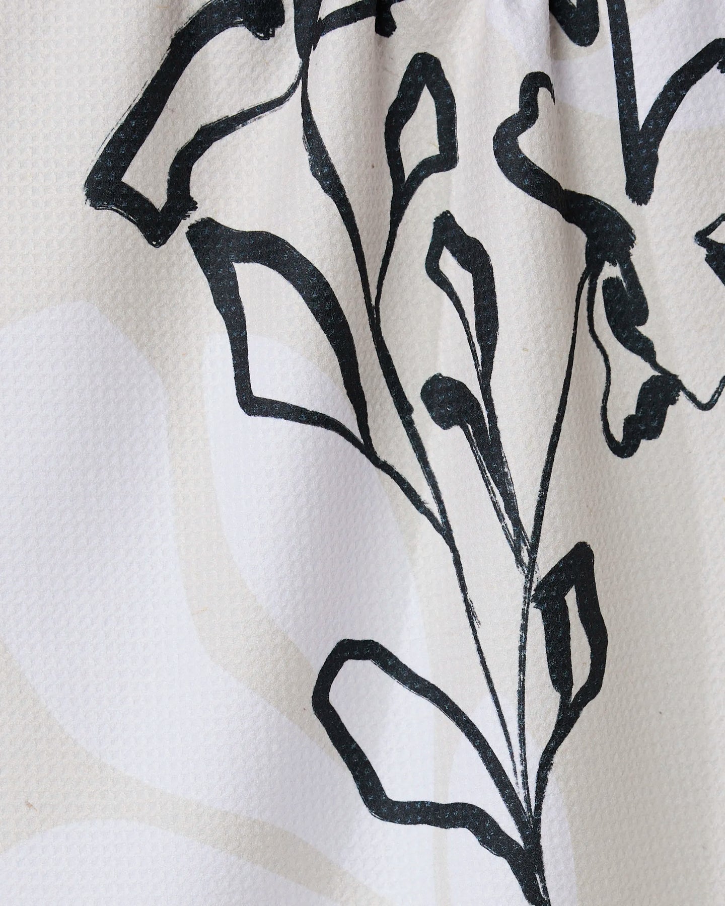 Reflected by GEOMETRY features a black line drawing of a stylized plant with leaves and stems on a textured white tea towel, crafted from recycled materials with subtle light beige patterns.