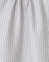 The Rideaux Neutre tea towel by GEOMETRY features white fabric with vertical stripes of small beige dots in a subtle geometric pattern. Slightly gathered at the top, its an eco-friendly and stylish choice for any kitchen.