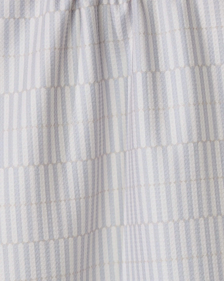 The Rideaux Neutre tea towel by GEOMETRY features white fabric with vertical stripes of small beige dots in a subtle geometric pattern. Slightly gathered at the top, its an eco-friendly and stylish choice for any kitchen.