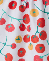 The Ripe kitchen towel by GEOMETRY features a red and yellow tomato pattern with teal green vines on textured white recycled fabric, combining style and eco-friendliness.