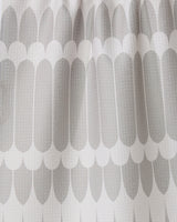 Close-up of the GEOMETRY Salle Dor white kitchen tea towel, showcasing a textured fabric with a repeating pattern of elongated, rounded grey shapes in overlapping rows for a modern look.