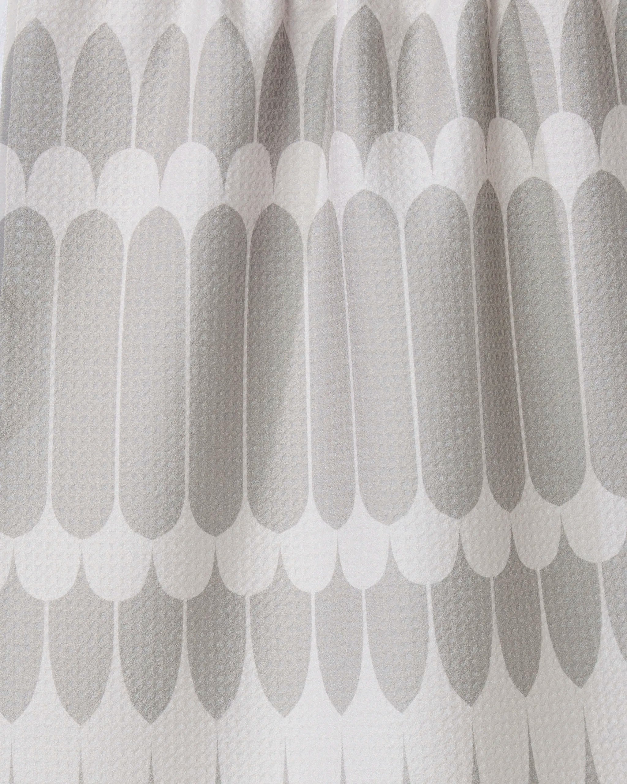 Close-up of the GEOMETRY Salle Dor white kitchen tea towel, showcasing a textured fabric with a repeating pattern of elongated, rounded grey shapes in overlapping rows for a modern look.