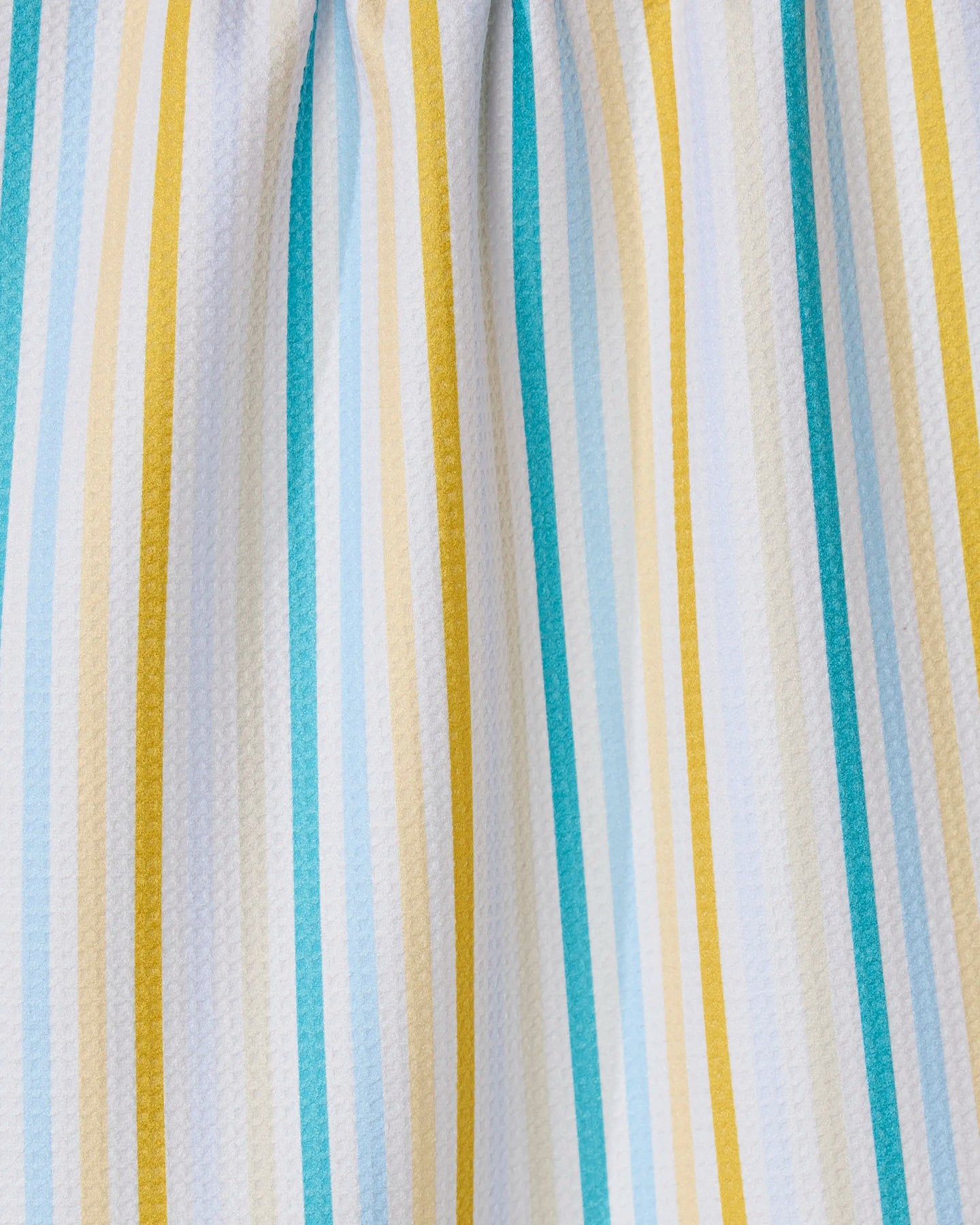 A close-up of GEOMETRYs Seaside Sunshine recycled kitchen towel, featuring vertical stripes in yellow, teal, light blue, and white. Its fabric is slightly gathered at the top for soft folds and a textured look.