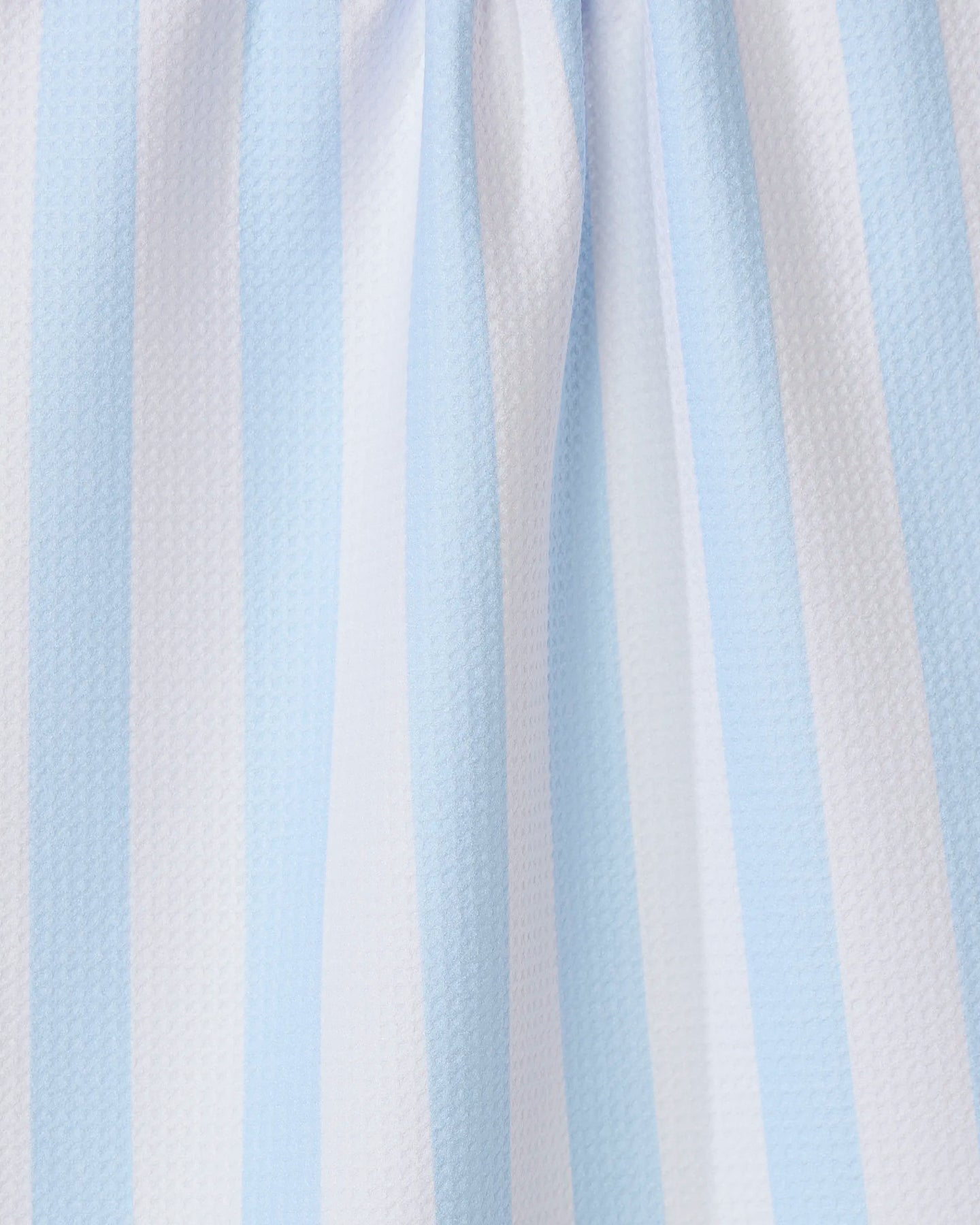 Close-up of the GEOMETRY Seaside Stripes recycled kitchen towel, showcasing its light blue and white vertical stripes, textured surface, and gentle folds.