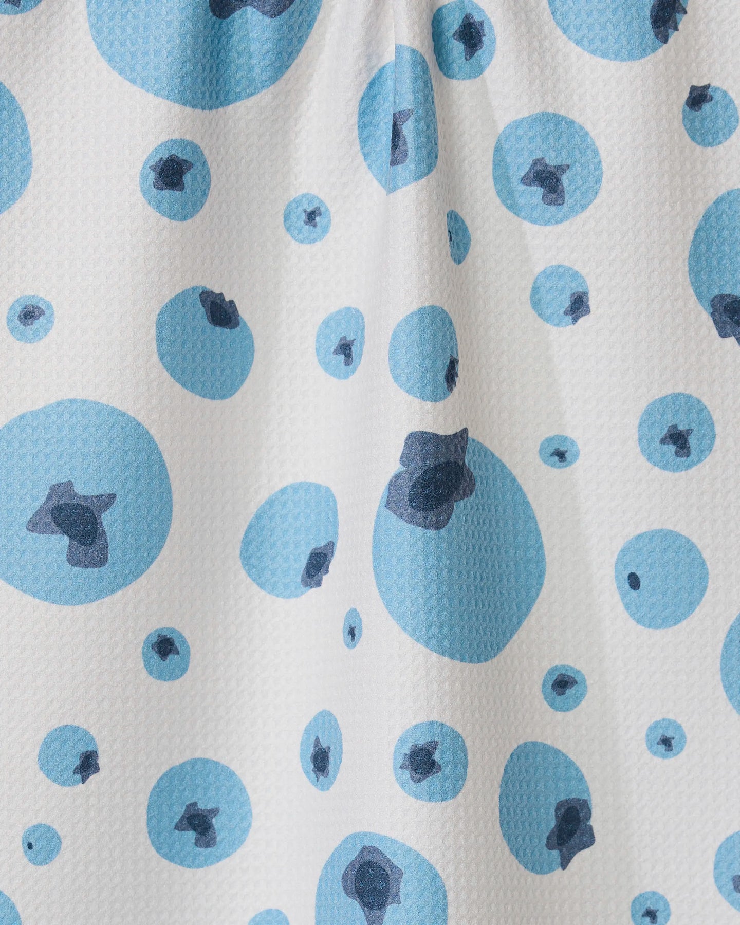 The GEOMETRY Sunny Blueberries tea towel features white Geoweave fabric with a textured surface and a scattered pattern of blue circles, each with a darker blue center, combining stylish design with functionality.