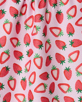 The Sweet Strawberry tea towel by GEOMETRY features a playful pink fabric with whole and sliced red strawberries, green leaves, and is crafted from recycled materials.