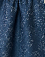 Close-up of the GEOMETRY Taps - Midnight towel, featuring a dark blue quick-drying fabric with light, circular concentric line patterns resembling ripples or tree rings scattered across the surface.