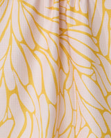 Close-up of GEOMETRY’s Tenderhearted: a quick-drying tea towel made from recycled materials, featuring a textured surface and an abstract yellow-and-white leaf pattern, softly gathered for added depth.