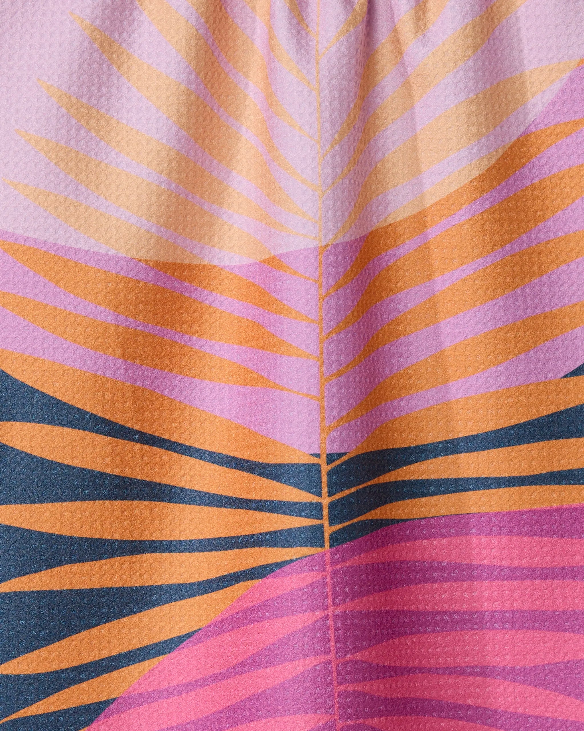 The Tropical Summer tea towel by GEOMETRY features a vibrant abstract design of radiating orange, pink, and dark blue lines on textured Geoweave fabric, crafted from recycled materials.